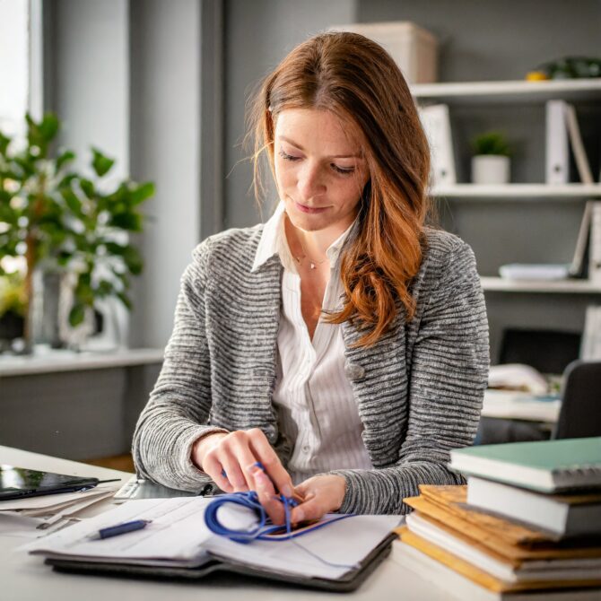 une consultant habillée en gris qui calcule son salaire